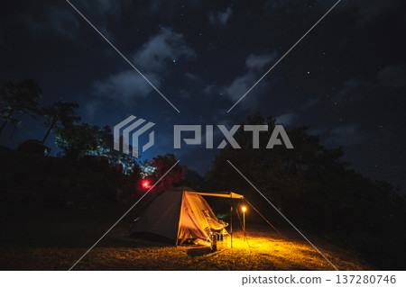nature traveling with orange camping tent on mountain with milky way and star background nature traveling with orange camping tent on mountain with milky way and star background 137280746