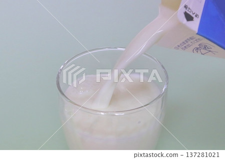 Pour milk into the glass Pour milk into the glass 137281021