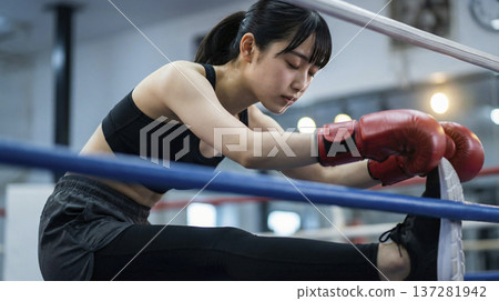 一名日本女子在拳擊台邊緣伸展雙腿 137281942