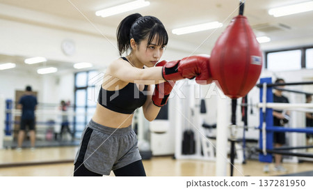 日本女子在明亮的健身房裡擊打拳擊球 137281950