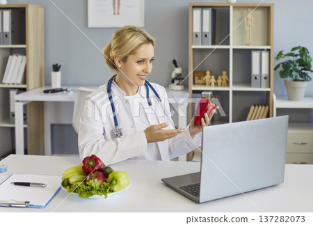Nutritionist doctor showing red pepper on laptop video consultation about diet 137282073