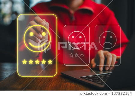 Person Interacting with Digital Feedback Interface Displaying Smiley Face and Star Ratings on Laptop in Modern Setting Person Interacting with Digital Feedback Interface Displaying Smiley Face and Star Ratings on Laptop in Modern Setting 137282194