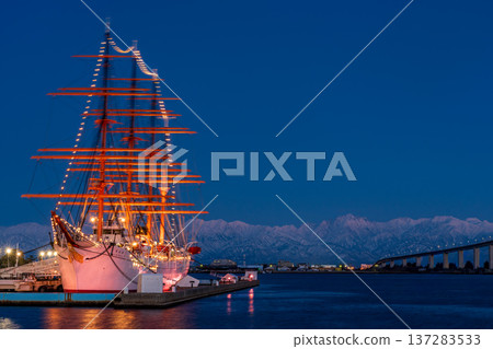 The pink Abenrot peaks of the Tateyama mountain range with Shinminato Bridge and Kaiwomaru in the foreground from Kaiwomaru Park in the evening 137283533