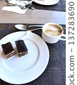 Cup of cappuccino and pieces of chocolate cake on plate 137283690
