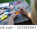 Young artists create colorful scenes on smooth pebbles, crafting unique handmade gifts for loved ones. 137283943