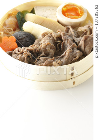 Sukiyaki bento box with plenty of ingredients photographed against a white background 137285362