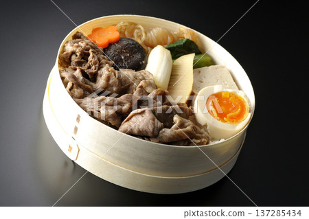 Sukiyaki bento box with plenty of ingredients photographed against a black background Sukiyaki bento box with plenty of ingredients photographed against a black background 137285434