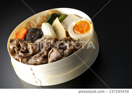 Sukiyaki bento box with plenty of ingredients photographed against a black background Sukiyaki bento box with plenty of ingredients photographed against a black background 137285438