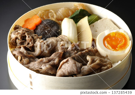 Sukiyaki bento box with plenty of ingredients photographed against a black background Sukiyaki bento box with plenty of ingredients photographed against a black background 137285439
