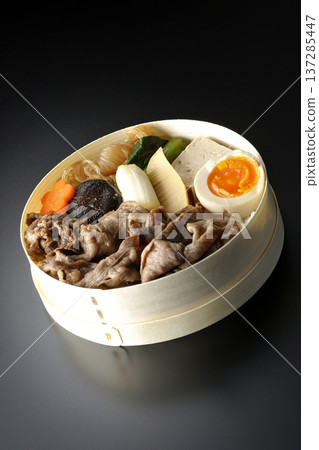 Sukiyaki bento box with plenty of ingredients photographed against a black background Sukiyaki bento box with plenty of ingredients photographed against a black background 137285447