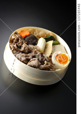 Sukiyaki bento box with plenty of ingredients photographed against a black background Sukiyaki bento box with plenty of ingredients photographed against a black background 137285448