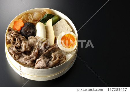 Sukiyaki bento box with plenty of ingredients photographed against a black background Sukiyaki bento box with plenty of ingredients photographed against a black background 137285457