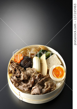 Sukiyaki bento box with plenty of ingredients photographed against a black background Sukiyaki bento box with plenty of ingredients photographed against a black background 137285463