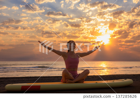Athlete woman practicing yoga at the beach during summer vacation. Slow motion Athlete woman practicing yoga at the beach during summer vacation. Slow motion 137285626