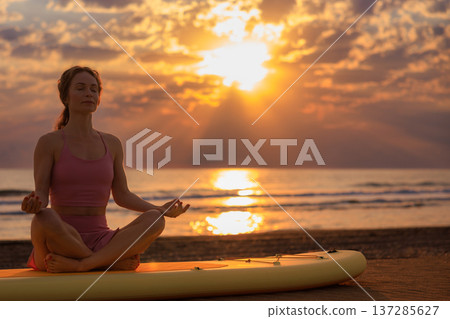 Athlete woman practicing yoga at the beach during summer vacation. Slow motion Athlete woman practicing yoga at the beach during summer vacation. Slow motion 137285627