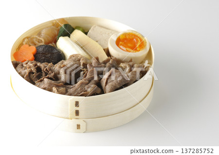 Sukiyaki bento box with plenty of ingredients photographed against a white background 137285752