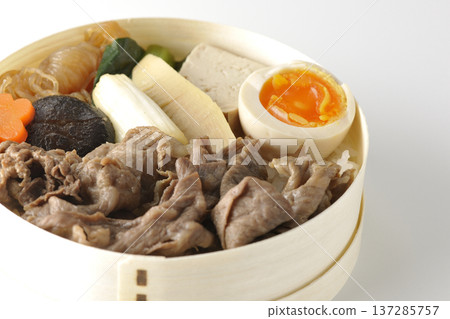 Sukiyaki bento box with plenty of ingredients photographed against a white background 137285757