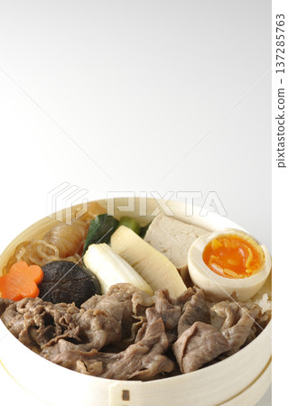 盛滿食材的壽喜燒便當盒,以白色背景拍攝。 盛滿食材的壽喜燒便當盒,以白色背景拍攝。 137285763