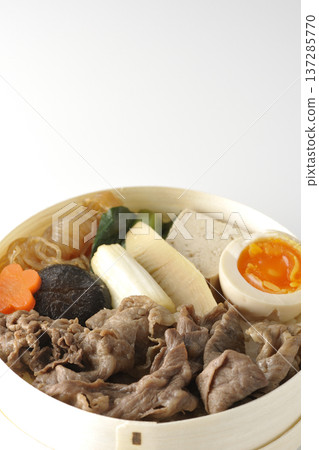 Sukiyaki bento box with plenty of ingredients photographed against a white background 137285770