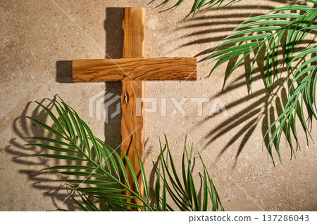 Wooden cross with palm leaves casting shadows Wooden cross with palm leaves casting shadows 137286043