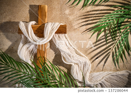 Wooden cross draped white fabric with palm leaves 137286044