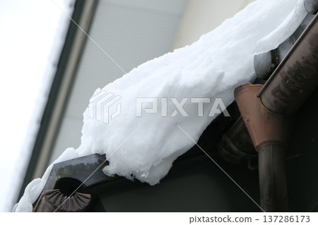Snow piled up on the roof, about to fall off Snow piled up on the roof, about to fall off 137286173