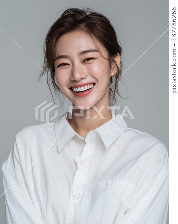 一張高品質的女性模特兒美照,她笑容清新,背景是灰色。 一張高品質的女性模特兒美照,她笑容清新,背景是灰色。 137286266