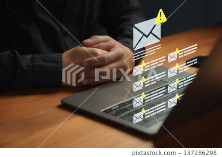 Person receiving phishing or spam email alerts on a laptop. Symbolizing data breach, email security risk, online scam detection, and protection against cyber threats. Cybersecurity concept. Person receiving phishing or spam email alerts on a laptop. Symbolizing data breach, email security risk, online scam detection, and protection against cyber threats. Cybersecurity concept. 137286298