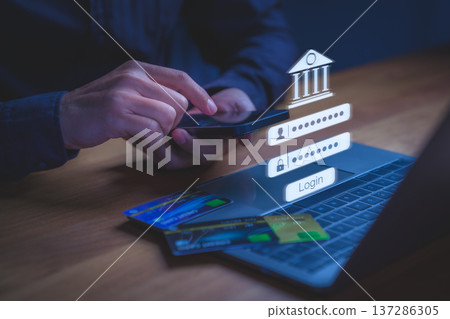 User accessing online banking through smartphone with digital login credential displayed above a laptop, symbolizing secure transaction, financial technology, authentication, and digital banking. User accessing online banking through smartphone with digital login credential displayed above a laptop, symbolizing secure transaction, financial technology, authentication, and digital banking. 137286305