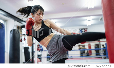 一名日本女子對著沙袋使出一記漂亮的中段踢擊。 137286364