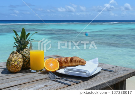 Fresh Tropical Breakfast Setup on Beachside with Pineapple, Juice, and Croissant 137288017