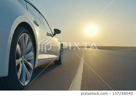 Low Angle Shot of a Car Wheel on an Open Highway with a Beautiful Sunset View Low Angle Shot of a Car Wheel on an Open Highway with a Beautiful Sunset View 137288040
