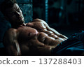 muscular man with defined abs resting after intense workout, sweat visible, motivational fitness 137288403