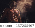 muscular man with defined abs resting after intense workout, sweat visible, motivational fitness 137288407