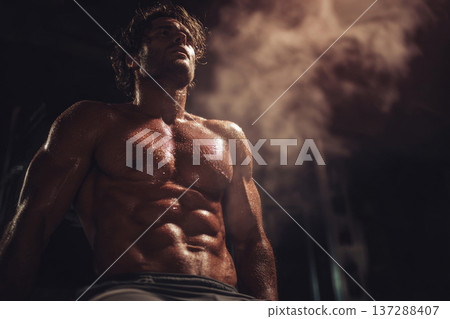 muscular man with defined abs resting after intense workout, sweat visible, motivational fitness 137288407
