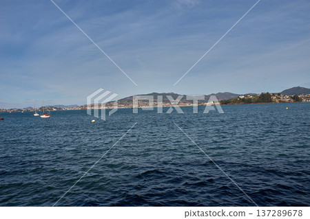 Coastal landscape of the Rias Baixas showing the blue sea and the silhouette of Panxon from the town of Baiona 137289678