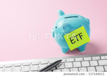Financial planning and savings for ETF investment. Piggy bank and computer keyboard on pink background 137289815