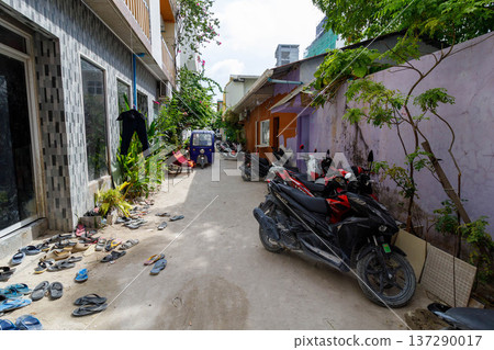 Sunlit alleyway with scooters and scattered shoes Sunlit alleyway with scooters and scattered shoes 137290017