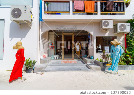 Bright sunlit street with vibrant red and blue outfits 137290023