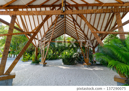 Wooden canopy shelters sandy path beneath 137290075
