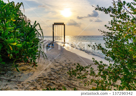 Sunset glows over tranquil beach scene Sunset glows over tranquil beach scene 137290342