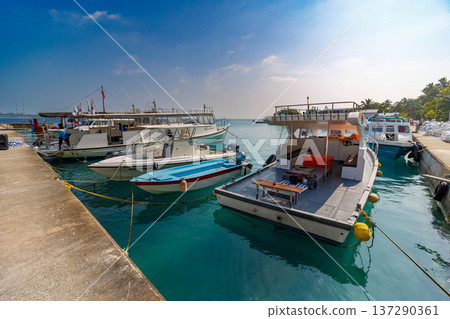 Calm turquoise waters surround moored boats Calm turquoise waters surround moored boats 137290361