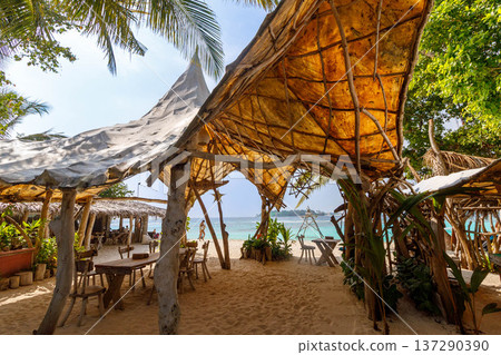Sun-dappled beach cafe invites calm relaxation Sun-dappled beach cafe invites calm relaxation 137290390