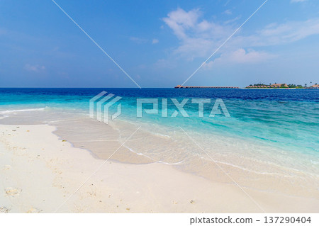 Crystal-clear waves lap against fine white sand 137290404