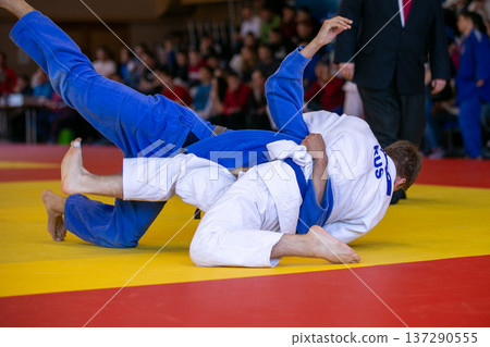 Russian judo athlete in white gi grappling Russian judo athlete in white gi grappling 137290555