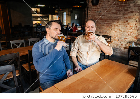 Two men enjoying beer tasting at local brewery pub Two men enjoying beer tasting at local brewery pub 137290569