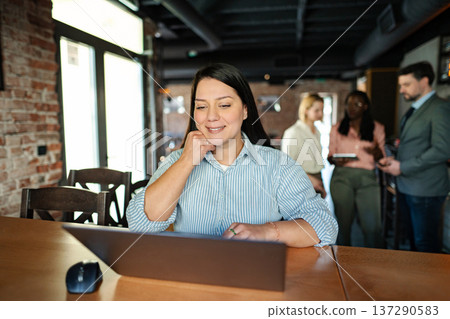 Woman working on laptop in modern coworking space Woman working on laptop in modern coworking space 137290583