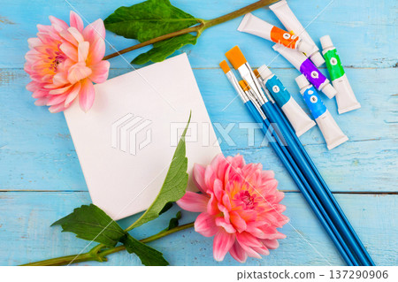 summer background. dahlias and a canvas on a blue wooden background. art. space for a text summer background. dahlias and a canvas on a blue wooden background. art. space for a text 137290906