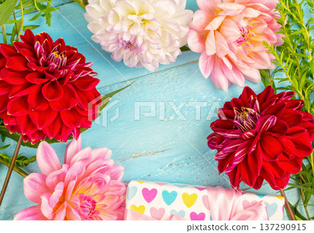 summer background. dahlias and a canvas on a blue wooden background. art. space for a text summer background. dahlias and a canvas on a blue wooden background. art. space for a text 137290915