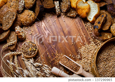 Assortment of baked bread on wooden table background Assortment of baked bread on wooden table background 137290965